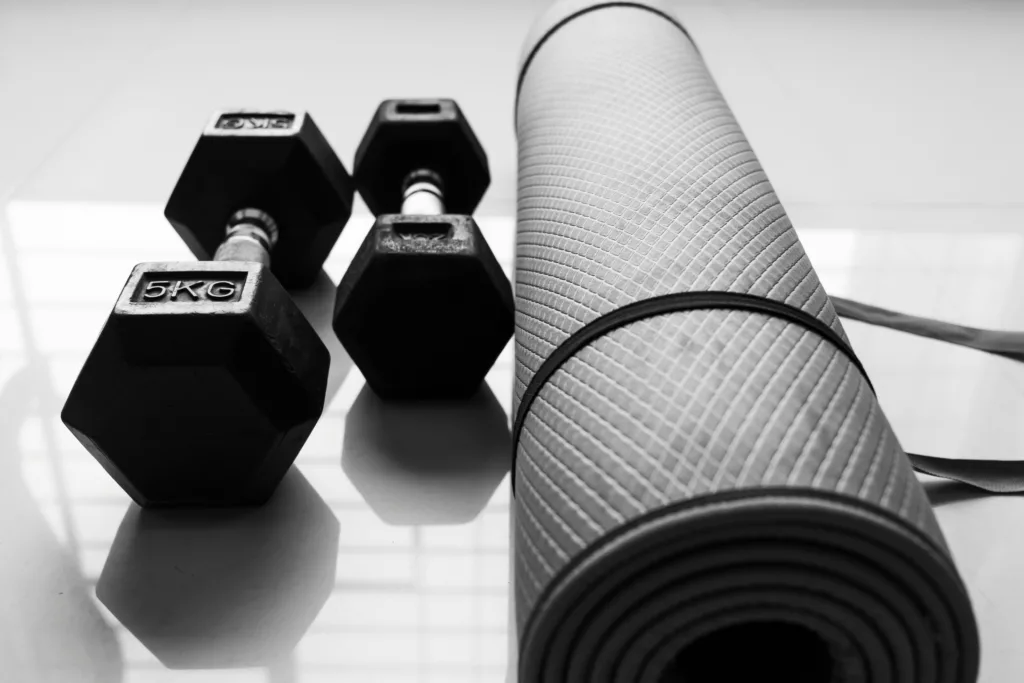An image of dumbbells and a yoga mat